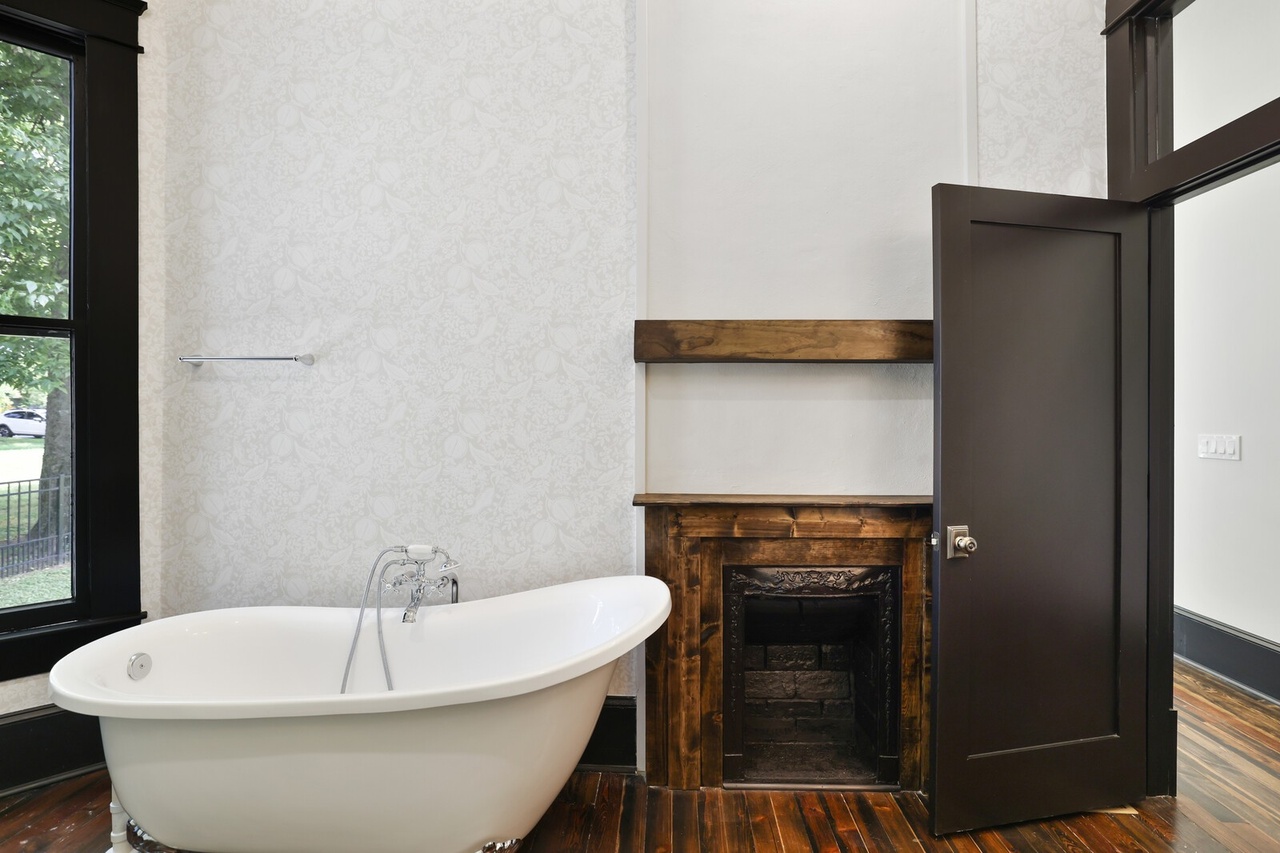 Master bathroom with clawfoot tub and fireplace